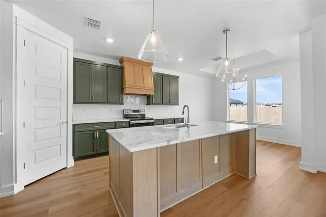 a kitchen with a sink and a stove top oven