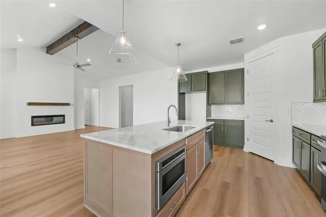 a kitchen with stainless steel appliances granite countertop a sink stove and refrigerator