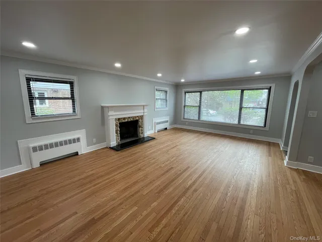 an empty room with large windows and fireplace