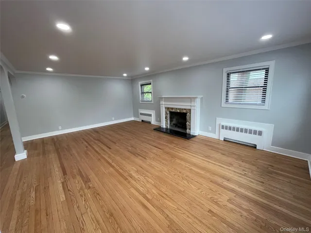 an empty room with wooden floor and fireplace