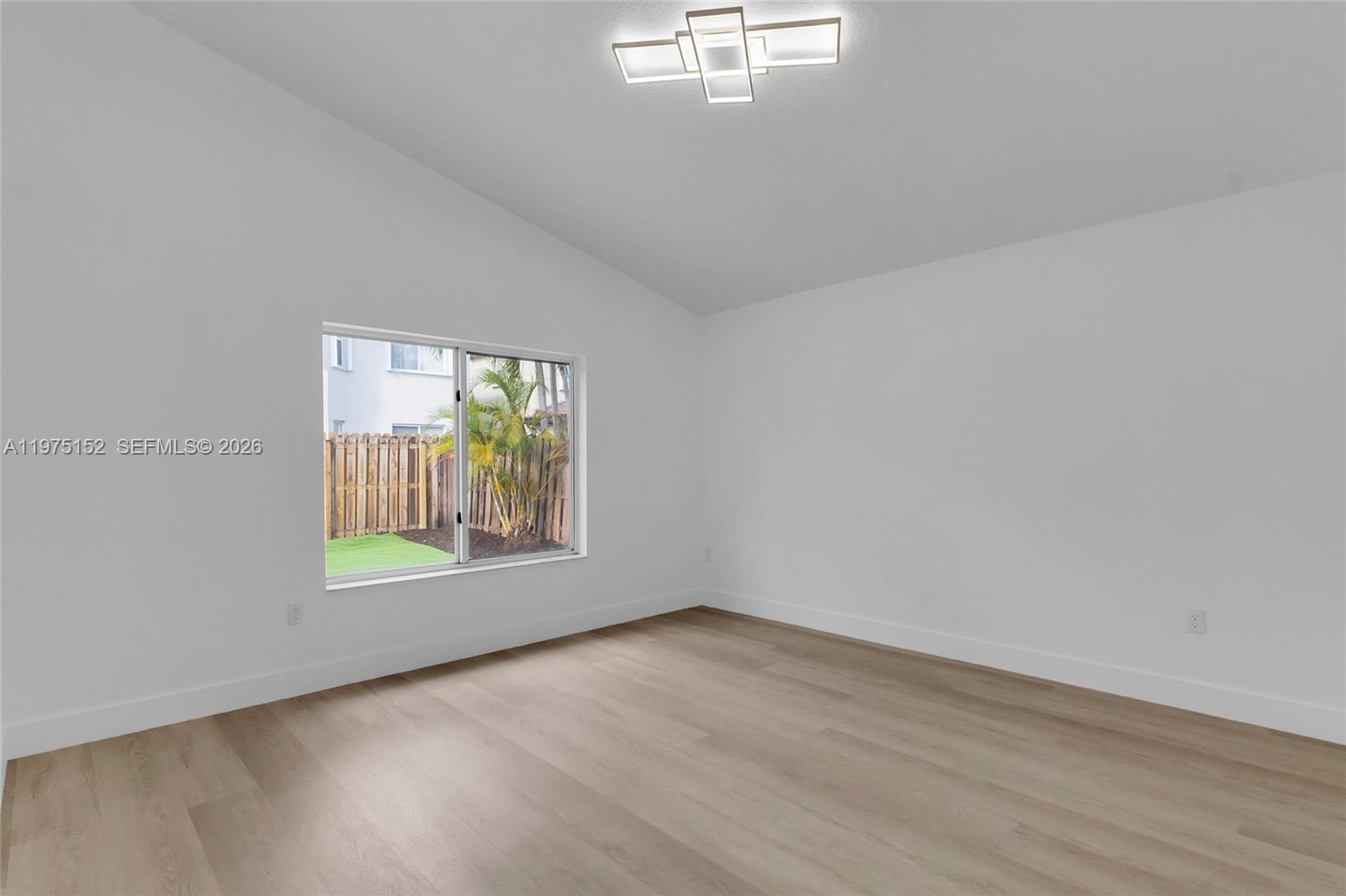 16333 Southwest 68th Terrace Miami, FL 33193 - Photo 14 of 32 an empty room with wooden floor and windows