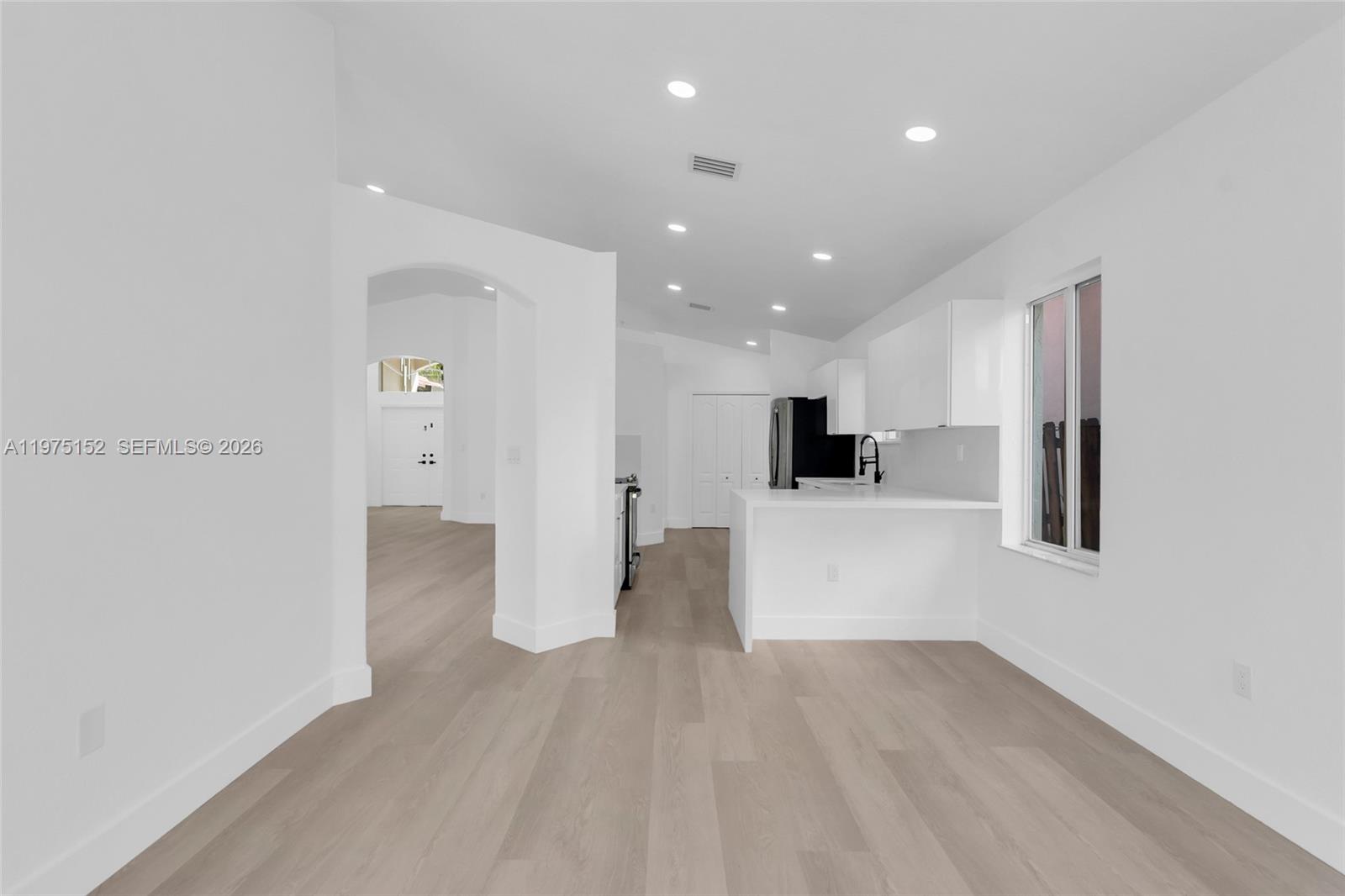 16333 Southwest 68th Terrace Miami, FL 33193 - Photo 20 of 32 a view of a living room with kitchen and a refrigerator