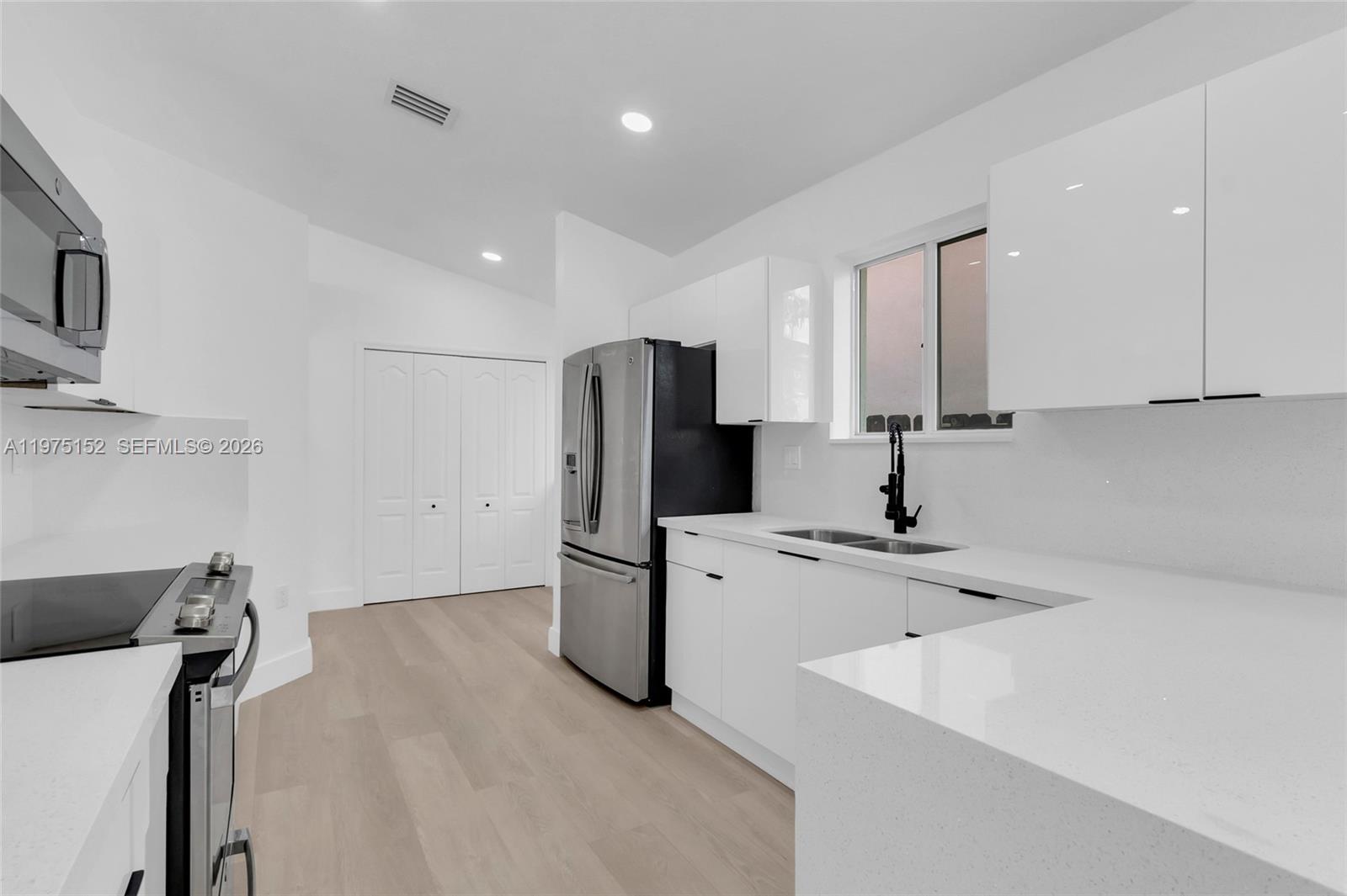 16333 Southwest 68th Terrace Miami, FL 33193 - Photo 21 of 32 a kitchen with stainless steel appliances a refrigerator sink and microwave