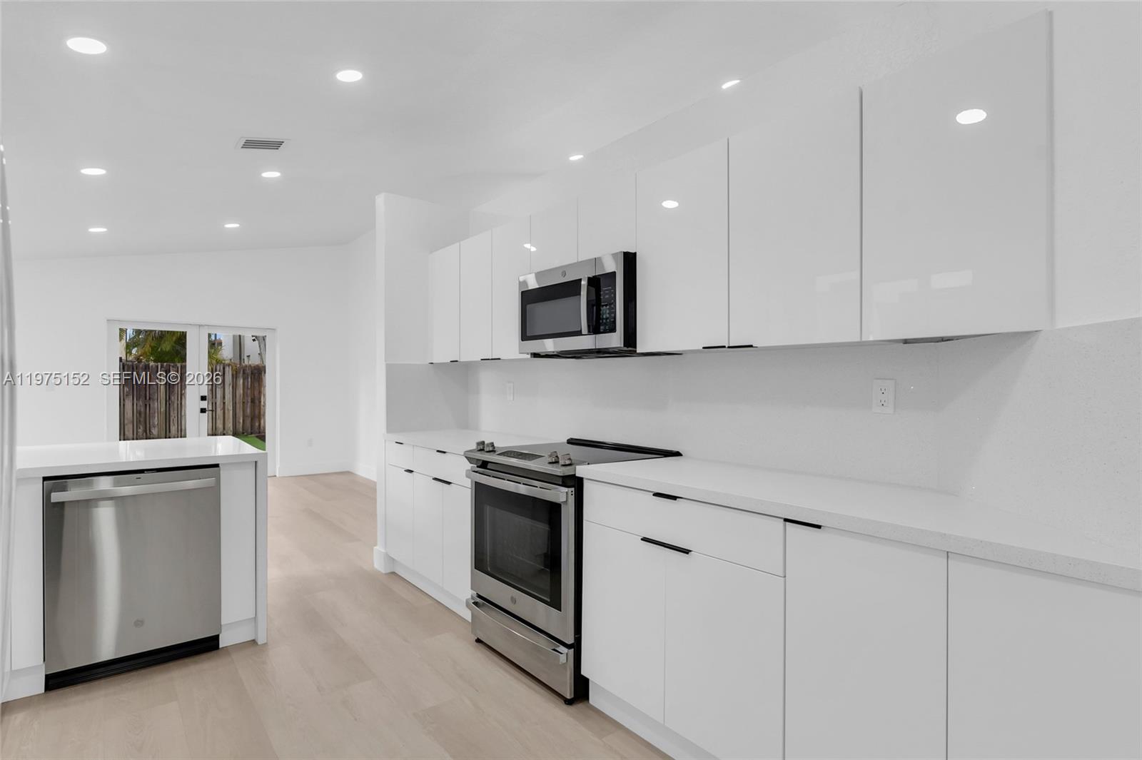 16333 Southwest 68th Terrace Miami, FL 33193 - Photo 22 of 32 a kitchen with stainless steel appliances granite countertop a stove a sink and a microwave