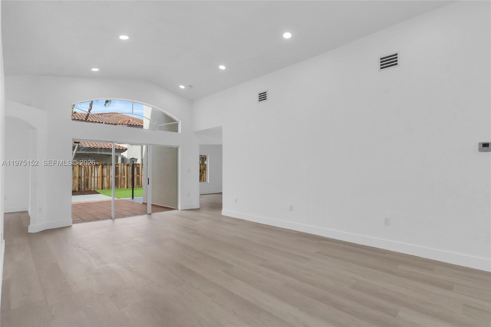 16333 Southwest 68th Terrace Miami, FL 33193 - Photo 3 of 32 wooden floor in an empty room with a window
