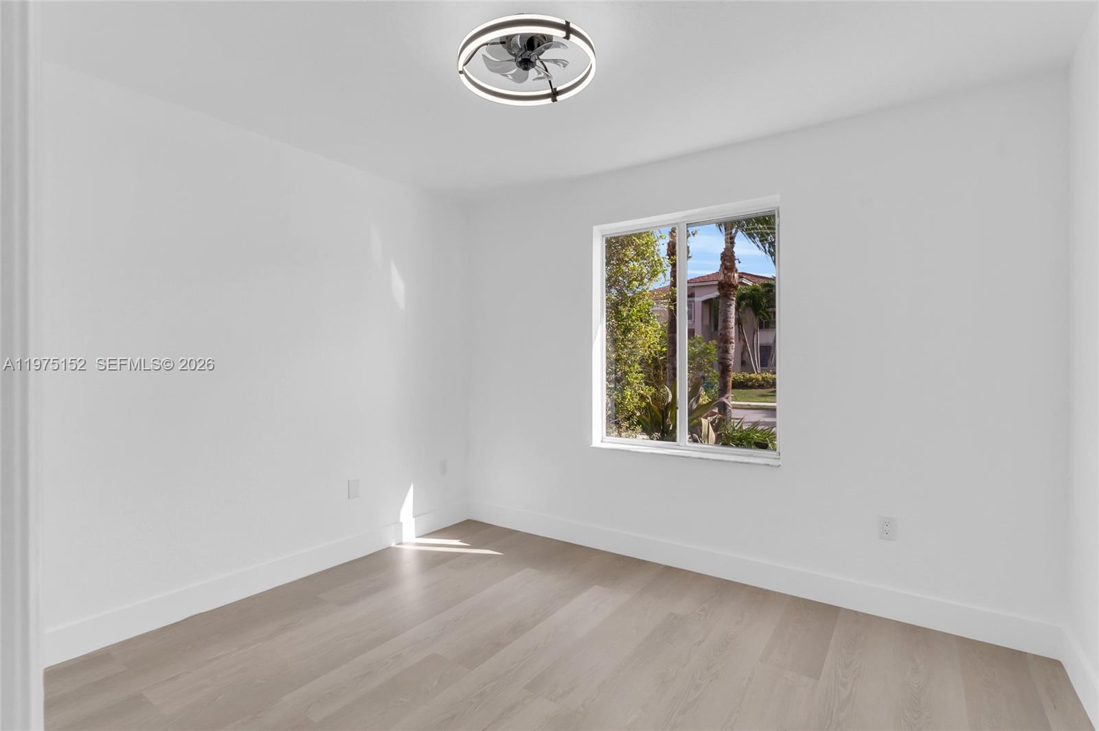 16333 Southwest 68th Terrace Miami, FL 33193 - Photo 8 of 32 an empty room with a window and a fan