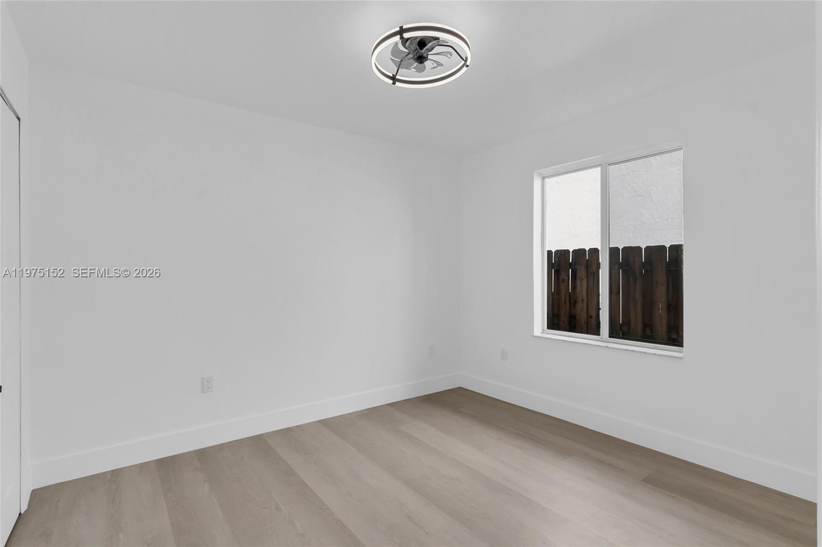 16333 Southwest 68th Terrace Miami, FL 33193 - Photo 10 of 32 an empty room with wooden floor and window