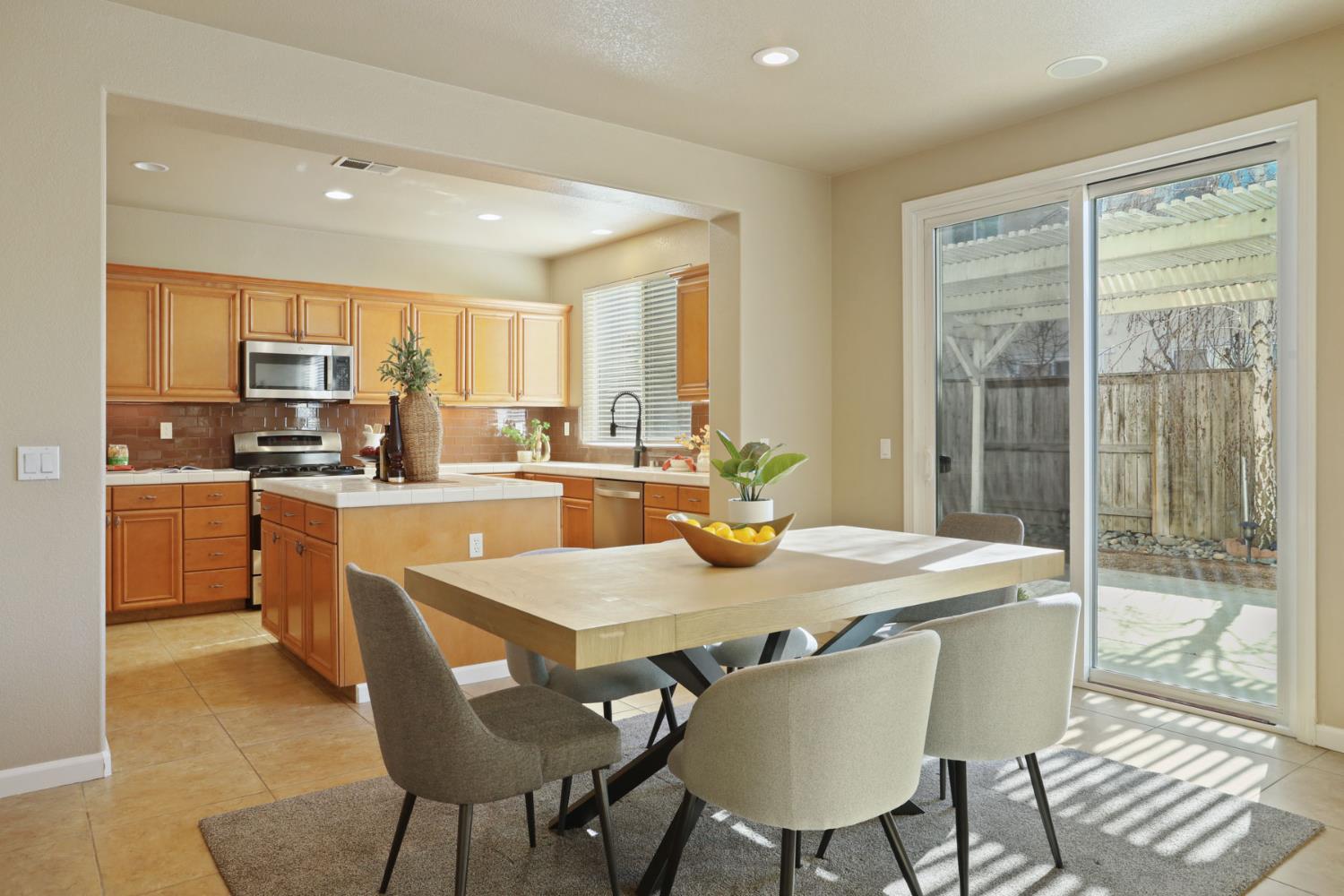5948 Pebblestone Way Stockton, CA 95219 - Photo 14 of 46 a dining room with stainless steel appliances granite countertop a table chairs and a refrigerator