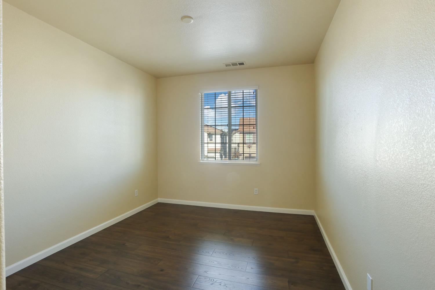 5948 Pebblestone Way Stockton, CA 95219 - Photo 34 of 46 an empty room with wooden floor and windows