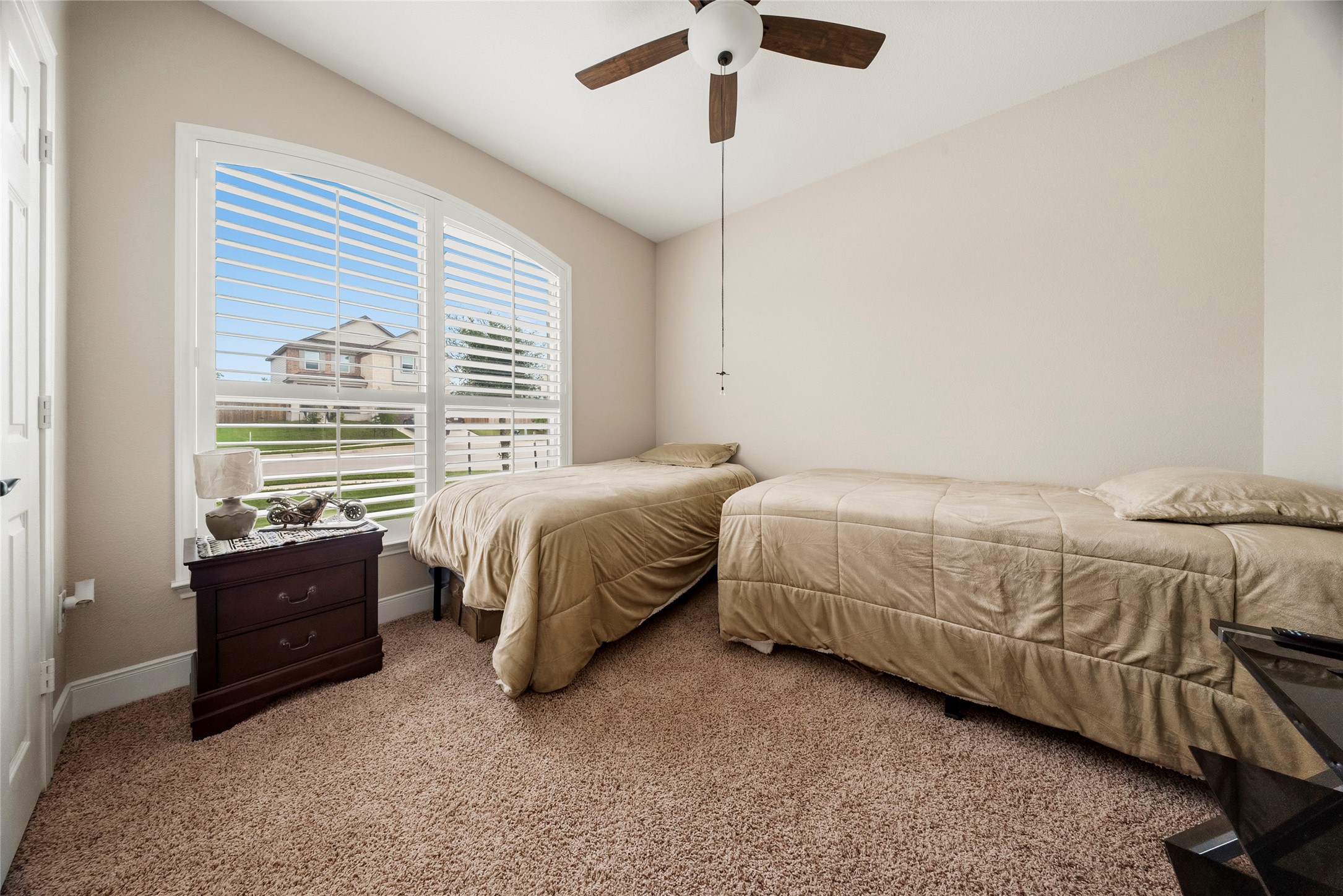 105 West Point Way Elgin, TX 78621 - Photo 13 of 27 Carpeted room featuring a large arched window with plantation shutters, a ceiling fan, and painted walls