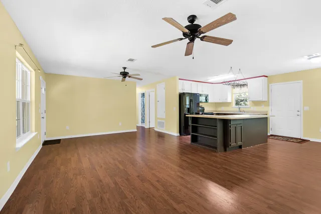 a kitchen with stainless steel appliances kitchen island hardwood floor and a sink