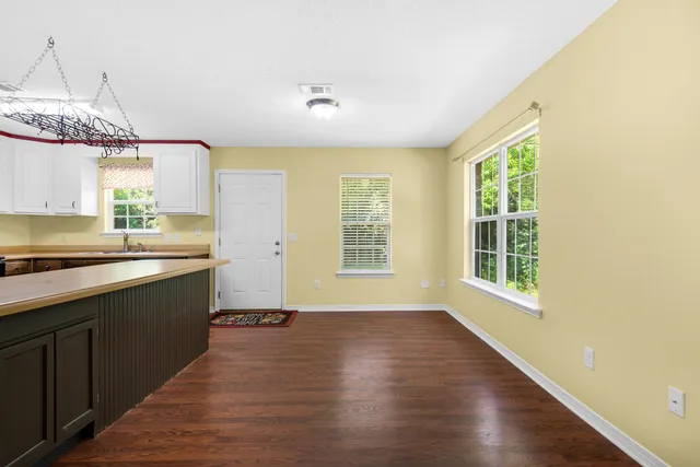 a large kitchen with granite countertop a large counter top space appliances and a window