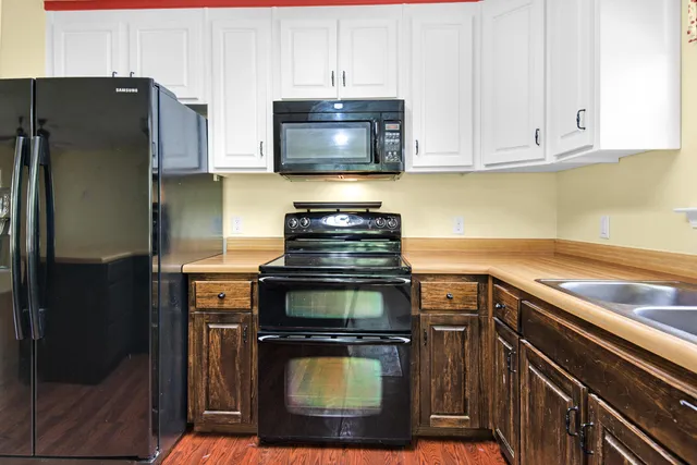 a kitchen with stainless steel appliances granite countertop a stove a refrigerator and a microwave