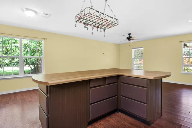 a kitchen with kitchen island a wooden floor and window