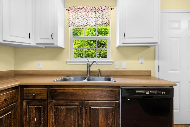 a kitchen with granite countertop a sink a stove and cabinets