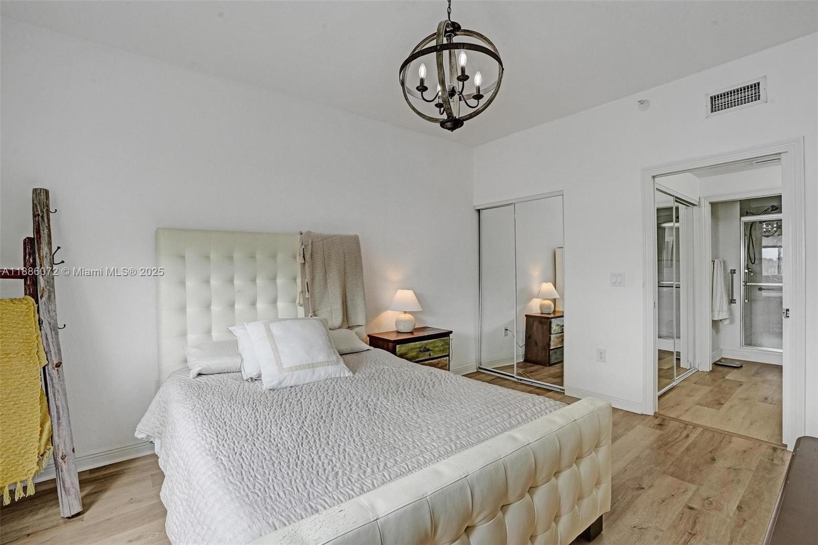 7635 Southampton Terrace, Unit 307 Tamarac, FL 33321 - Photo 28 of 43 a bedroom with a bed and a chandelier