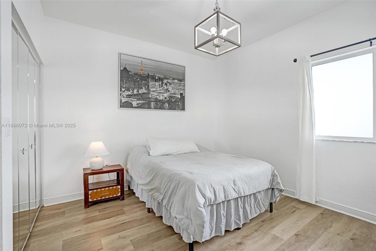 7635 Southampton Terrace, Unit 307 Tamarac, FL 33321 - Photo 31 of 43 a bedroom with a bed and wooden floor