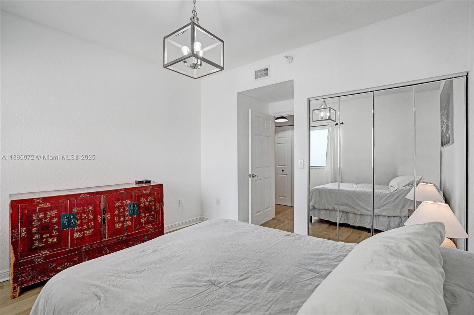 7635 Southampton Terrace, Unit 307 Tamarac, FL 33321 - Photo 33 of 43 a bedroom with a bed and a chandelier