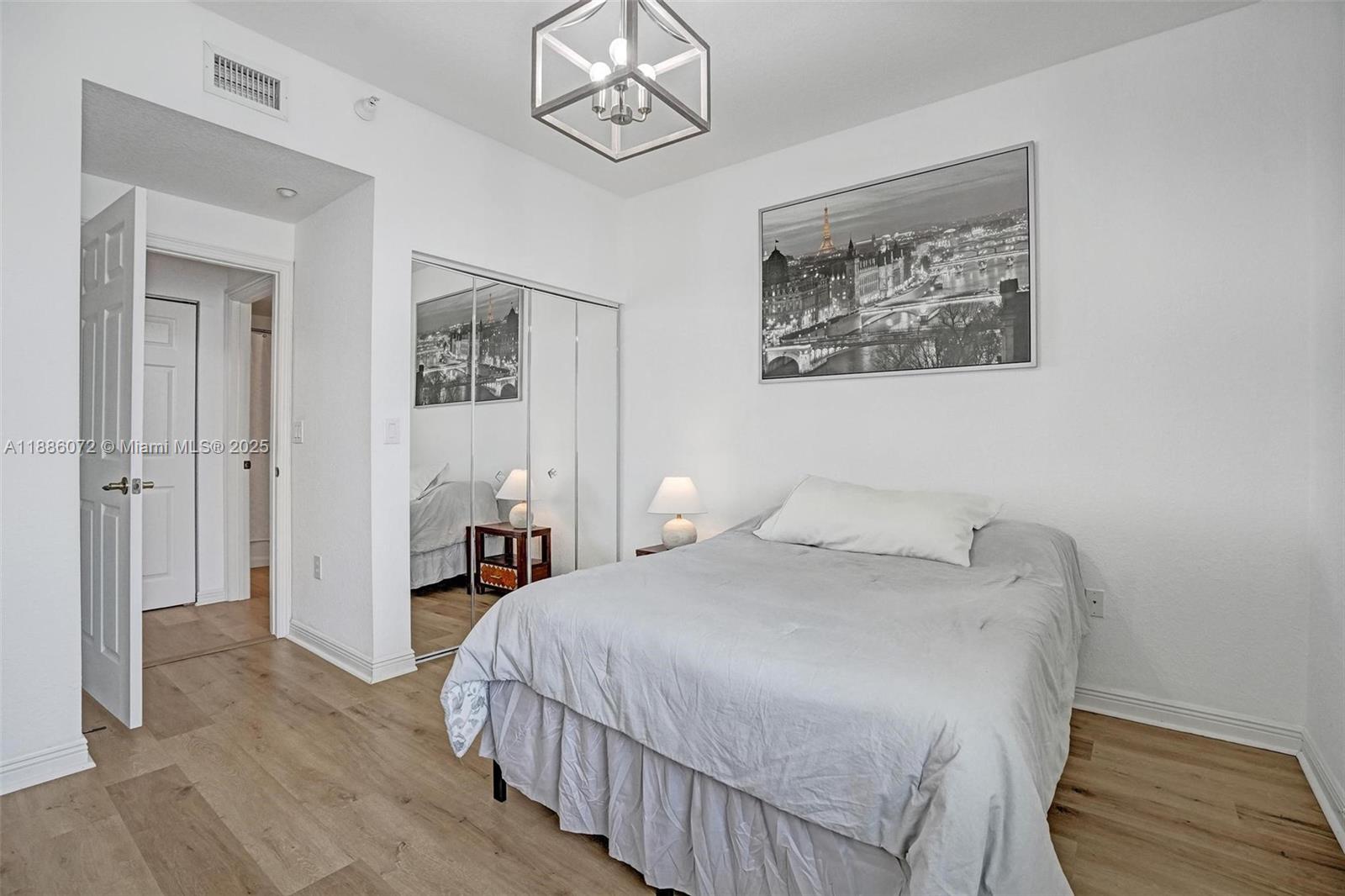 7635 Southampton Terrace, Unit 307 Tamarac, FL 33321 - Photo 34 of 43 a bedroom with a bed and a chandelier