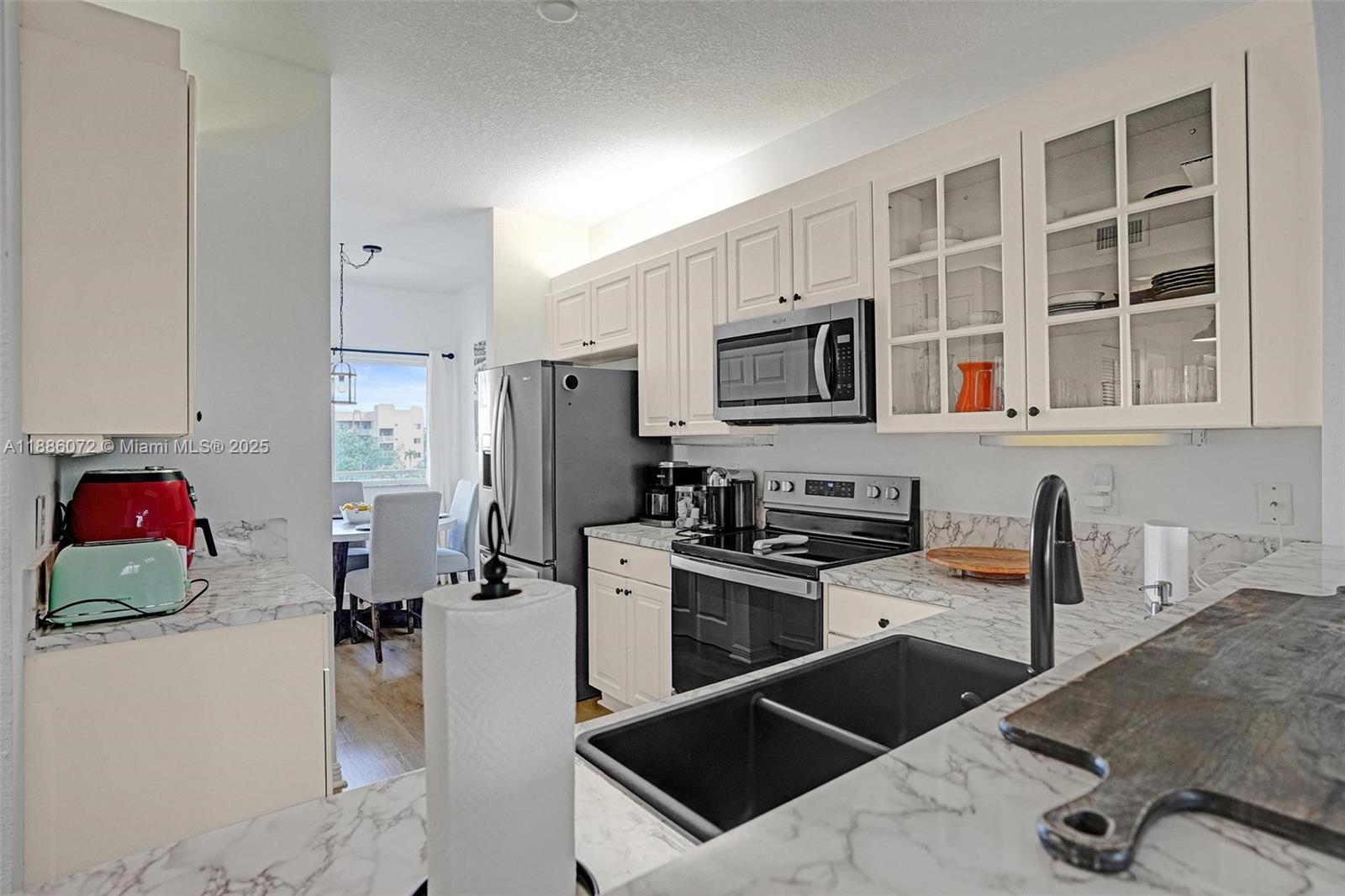7635 Southampton Terrace, Unit 307 Tamarac, FL 33321 - Photo 9 of 43 a kitchen with stainless steel appliances a stove a sink a microwave and refrigerator