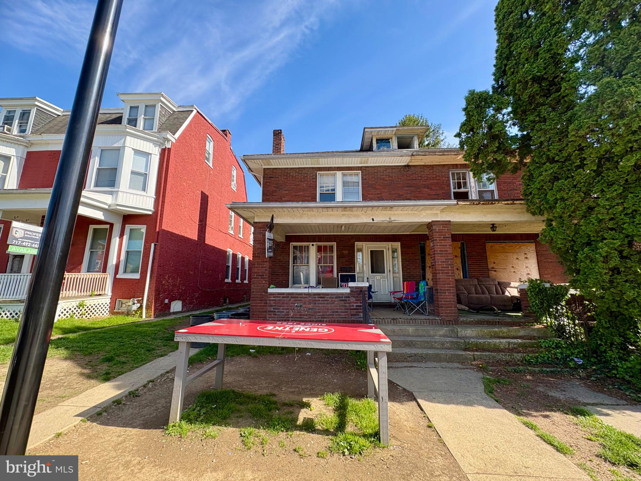 a front view of brick house with a yard