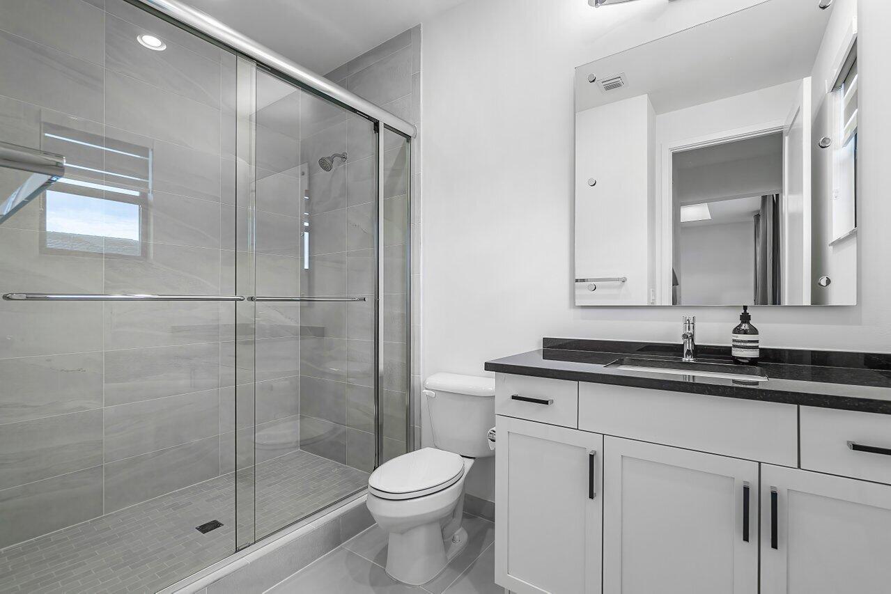 17092 Teton River Road Boca Raton, FL 33496 - Photo 18 of 58 a bathroom with a granite countertop sink a toilet and a mirror