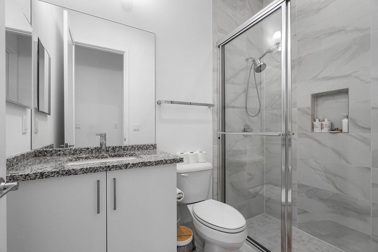 17092 Teton River Road Boca Raton, FL 33496 - Photo 30 of 58 a bathroom with a granite countertop sink toilet and shower