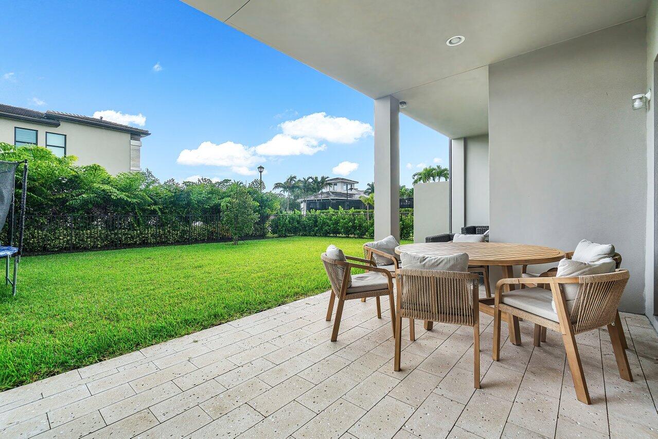 17092 Teton River Road Boca Raton, FL 33496 - Photo 31 of 58 a dining area with a table and chairs and garden