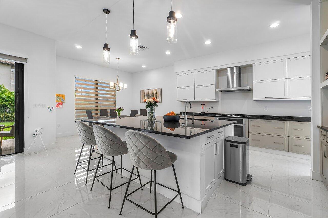 17092 Teton River Road Boca Raton, FL 33496 - Photo 4 of 58 a kitchen with stainless steel appliances granite countertop a sink a stove a refrigerator and island with wooden floor