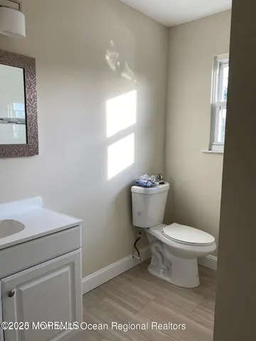 a bathroom with a toilet a sink and a window