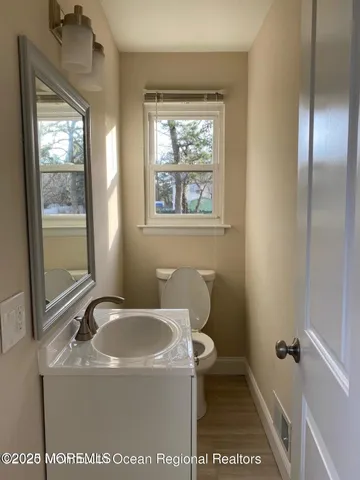a bathroom with a sink a toilet and a window