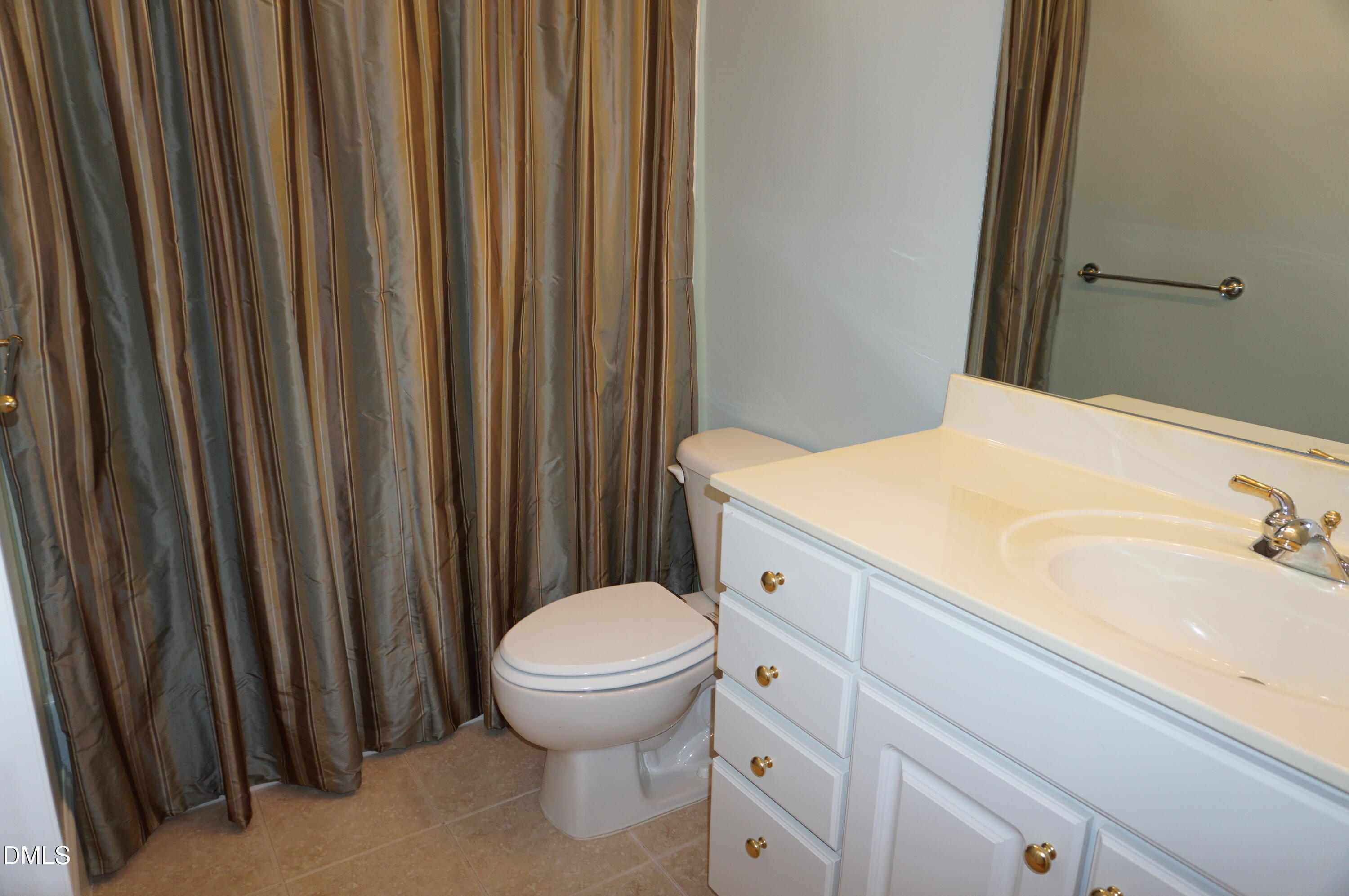 3701 Baron Cooper Pass, Unit 104 Raleigh, NC 27612 - Photo 40 of 52 a bathroom with a sink a toilet and shower curtain