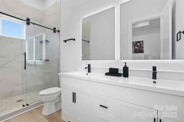 a bathroom with a double vanity sink toilet and shower