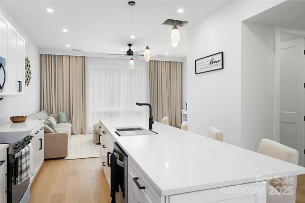 a room with a bed a chandelier and a window