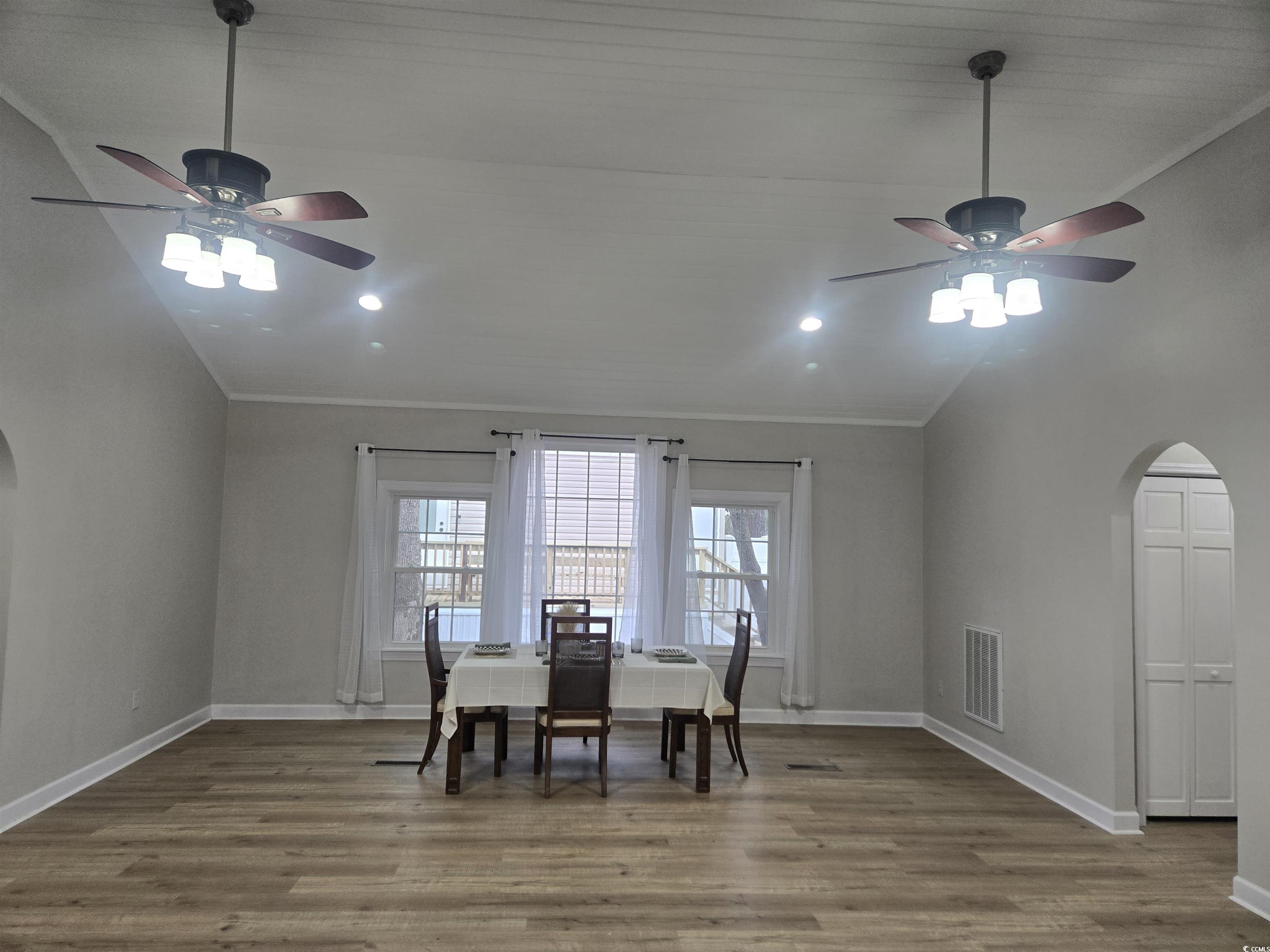 517 Porter Drive Murrells Inlet, SC 29576 - Photo 14 of 40 Dining space with arched walkways, vaulted ceiling, a ceiling fan, light wood finished floors, and crown molding