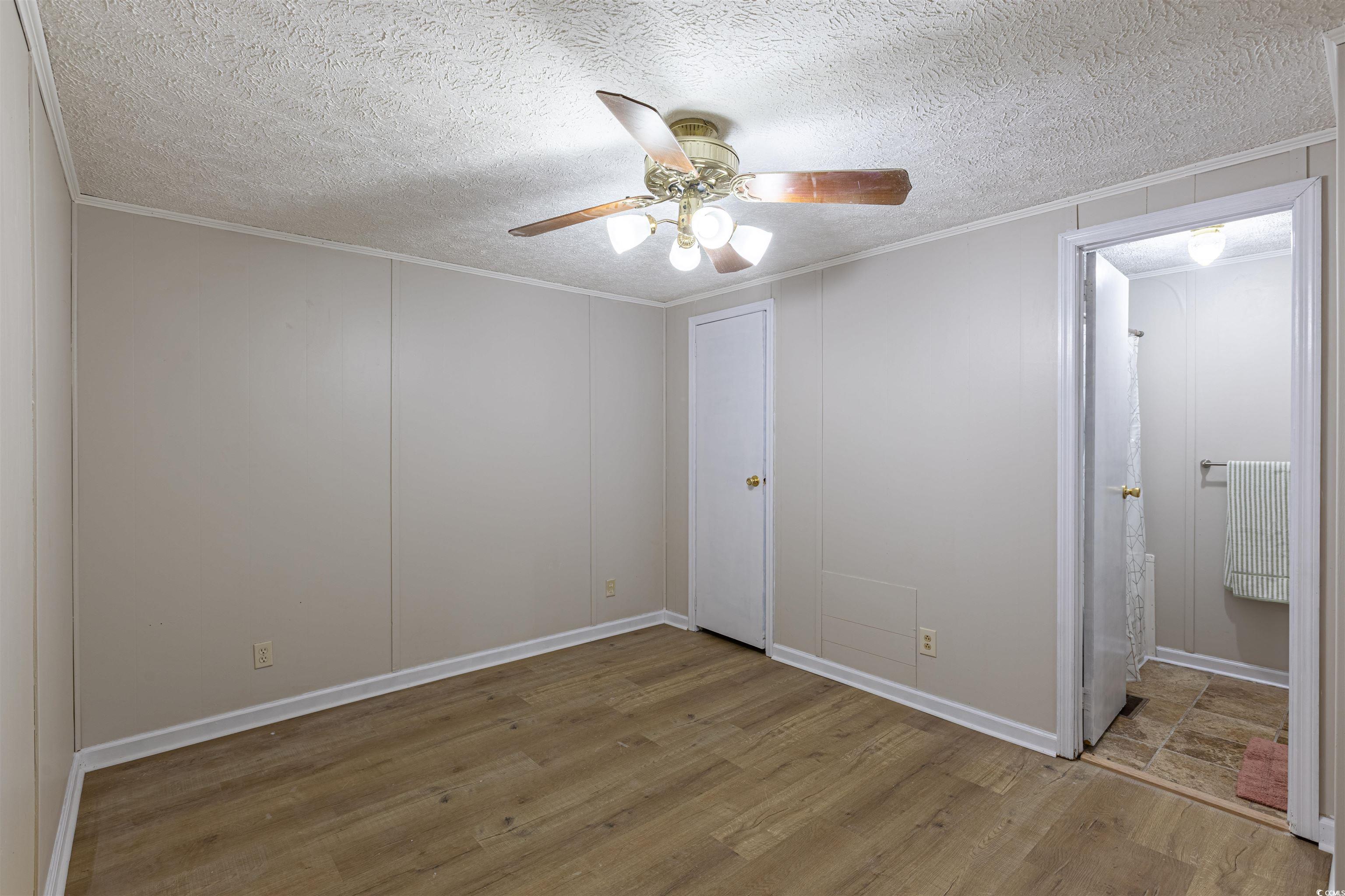517 Porter Drive Murrells Inlet, SC 29576 - Photo 30 of 40 Unfurnished bedroom featuring wood finished floors, a textured ceiling, a decorative wall, ceiling fan, and ornamental molding
