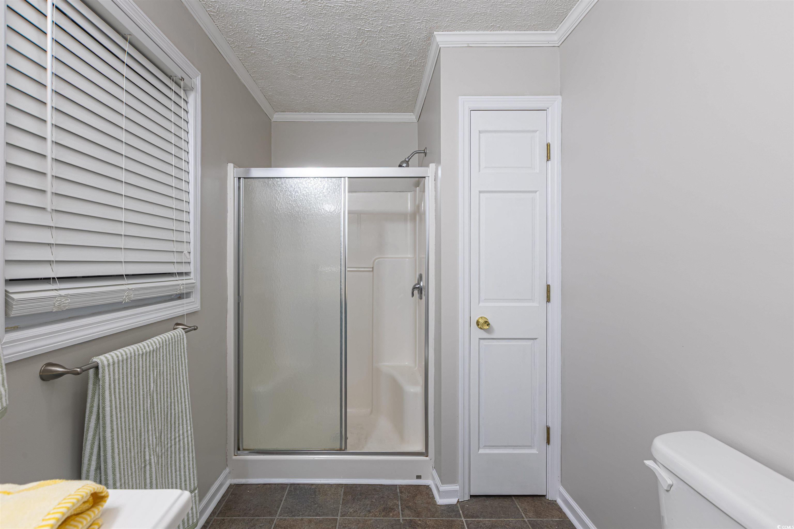 517 Porter Drive Murrells Inlet, SC 29576 - Photo 35 of 40 Full bathroom with a textured ceiling, a stall shower, and ornamental molding