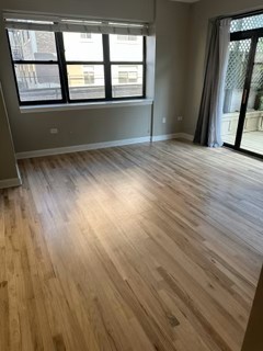 1529 South State Street, Unit 4B Chicago, IL 60605 - Photo 6 of 16 an empty room with wooden floor and windows