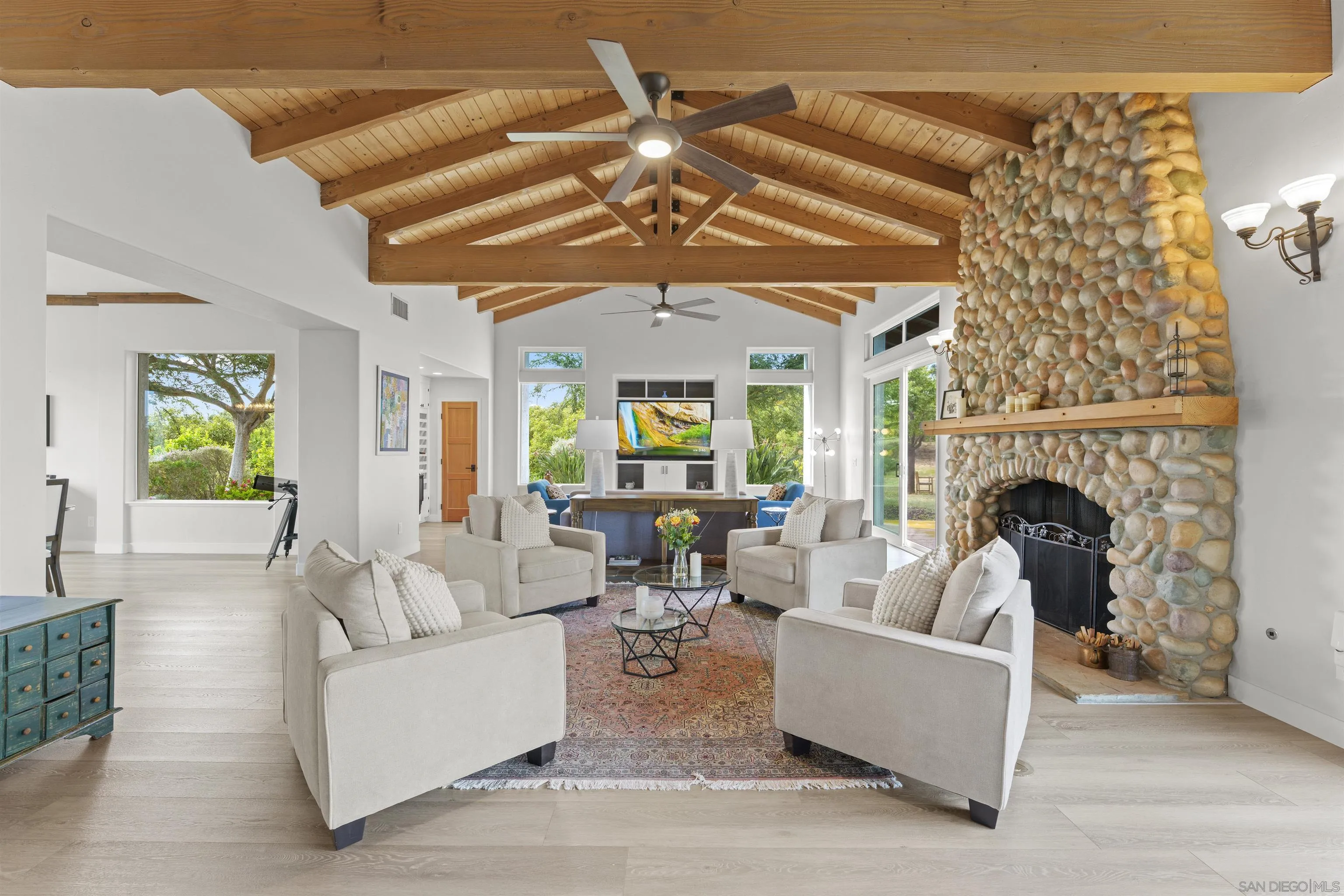 30659 Diaz Road Valley Center, CA 92082 - Photo 4 of 44 a living room with furniture a fireplace and a chandelier