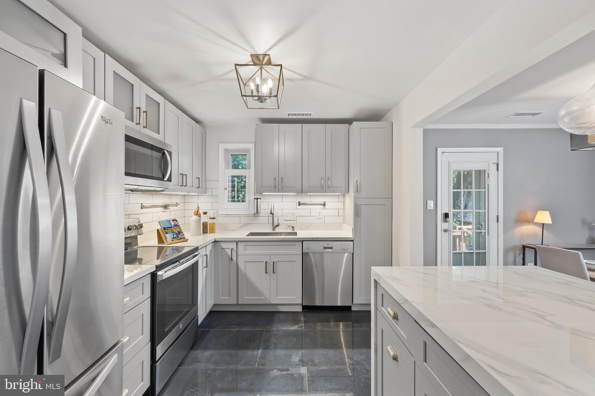 6721 Kenwood Forest Lane, Unit 45 Chevy Chase, MD 20815 - Photo 11 of 35 a kitchen with stainless steel appliances a sink stove refrigerator and cabinets