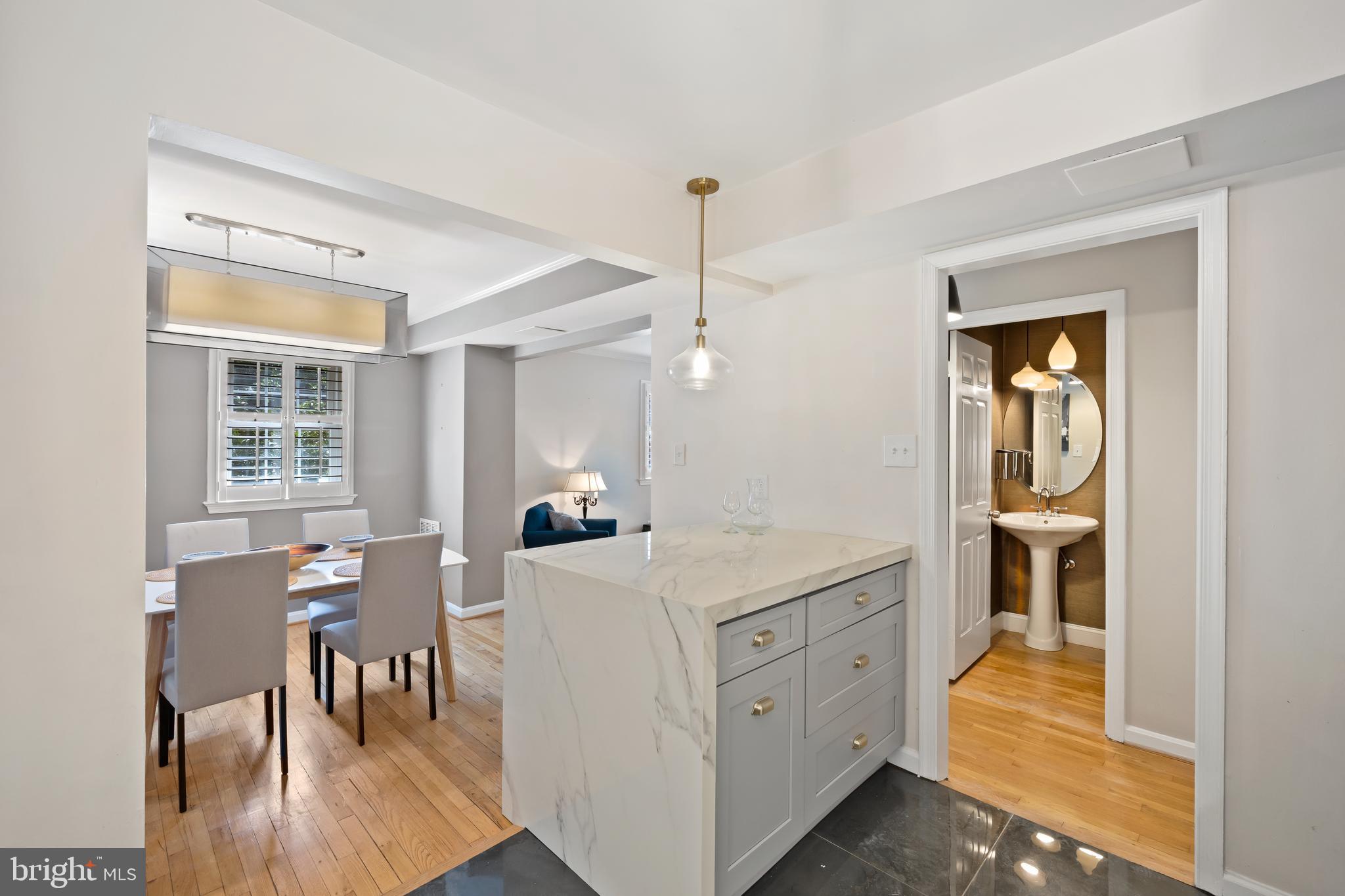 6721 Kenwood Forest Lane, Unit 45 Chevy Chase, MD 20815 - Photo 12 of 35 a kitchen with a stove a sink a dining table and chairs