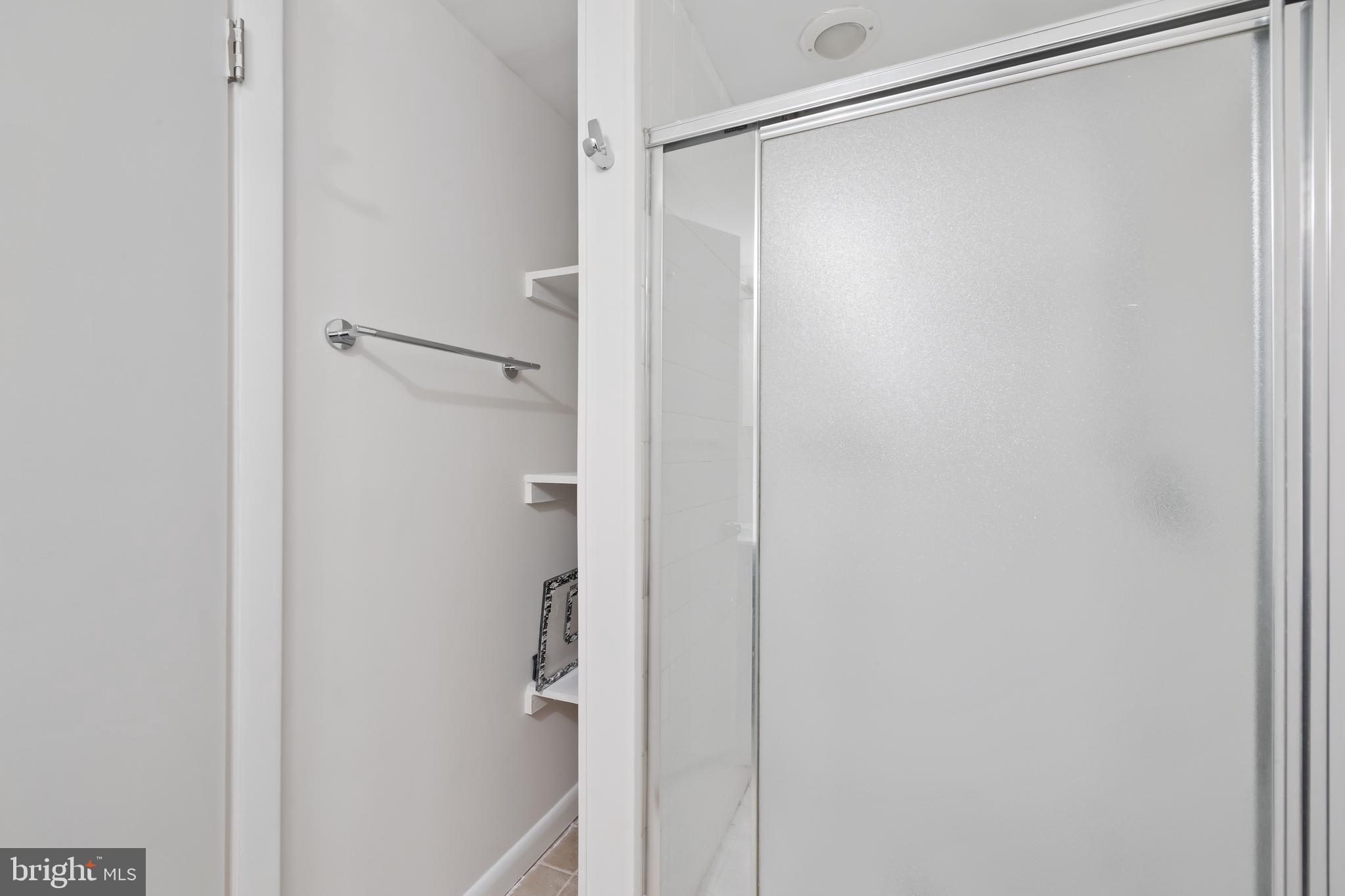 6721 Kenwood Forest Lane, Unit 45 Chevy Chase, MD 20815 - Photo 28 of 35 a bathroom with a glass shower door