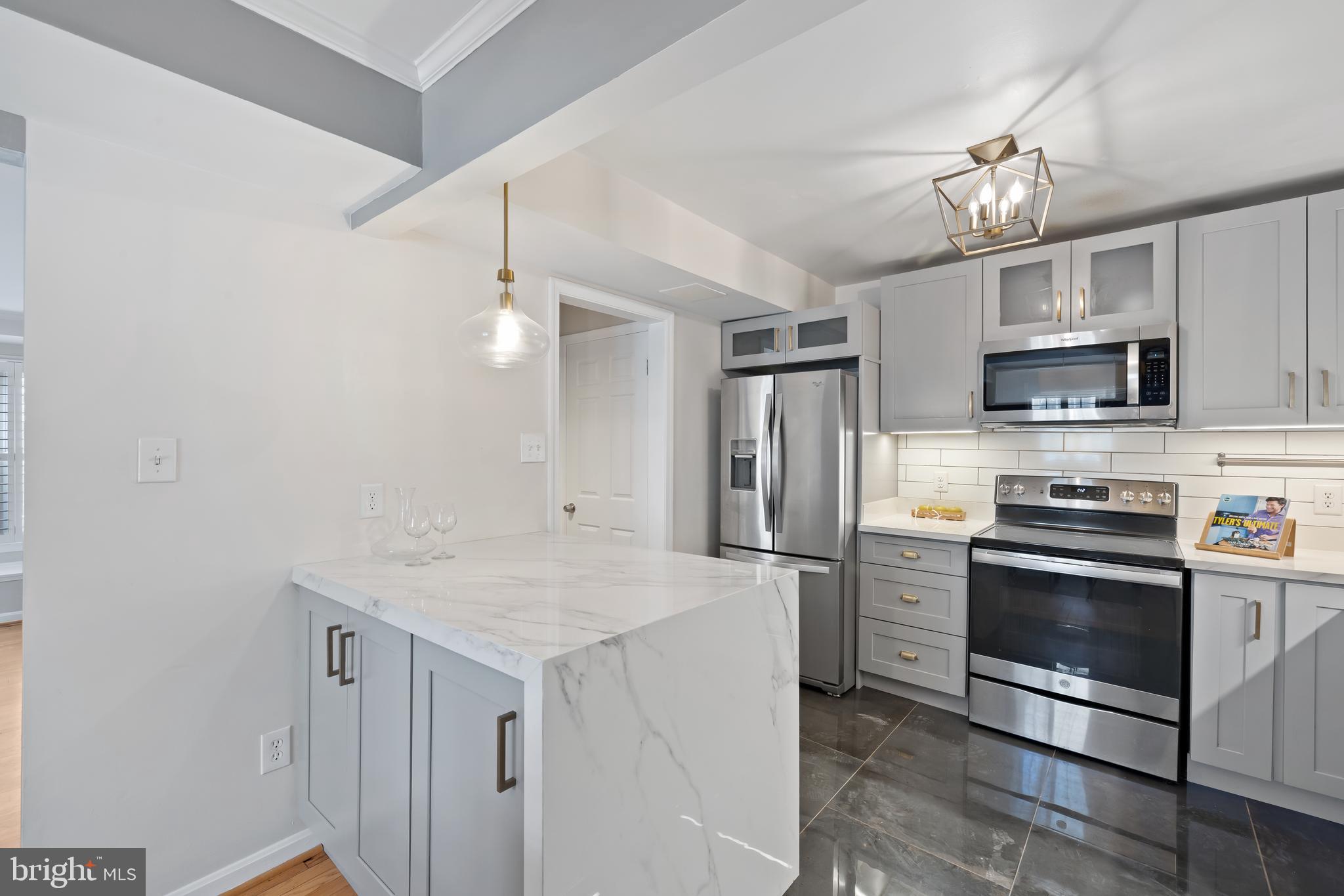 6721 Kenwood Forest Lane, Unit 45 Chevy Chase, MD 20815 - Photo 10 of 35 a kitchen with kitchen island a sink stainless steel appliances and cabinets