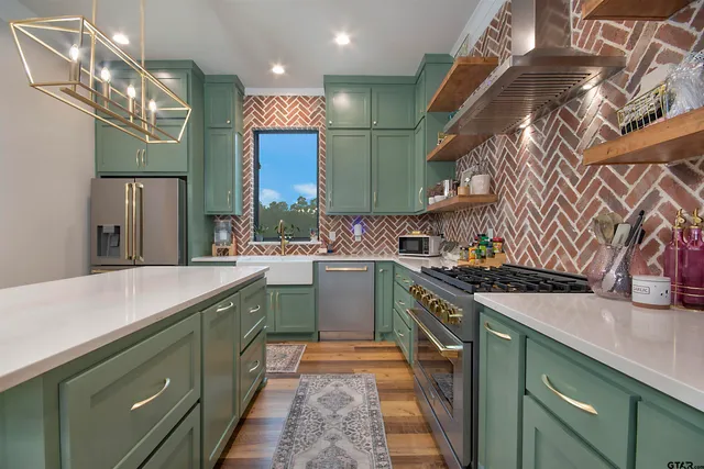 a kitchen that has a kitchen island wooden cabinets and stainless steel appliances