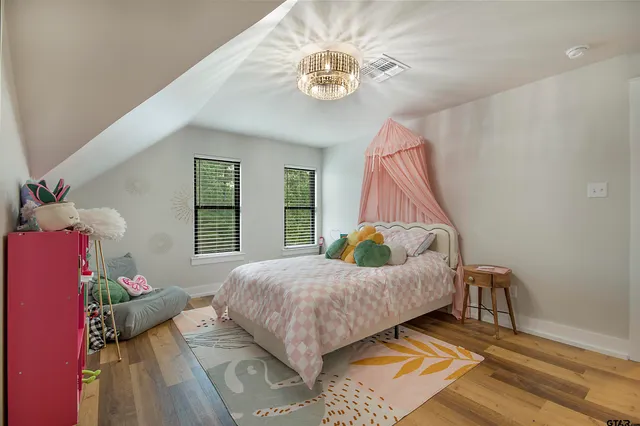 a bedroom with bed and wooden floor