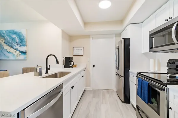 a kitchen with stainless steel appliances a stove microwave and sink
