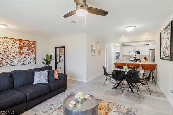 a living room with furniture kitchen view and a dining table