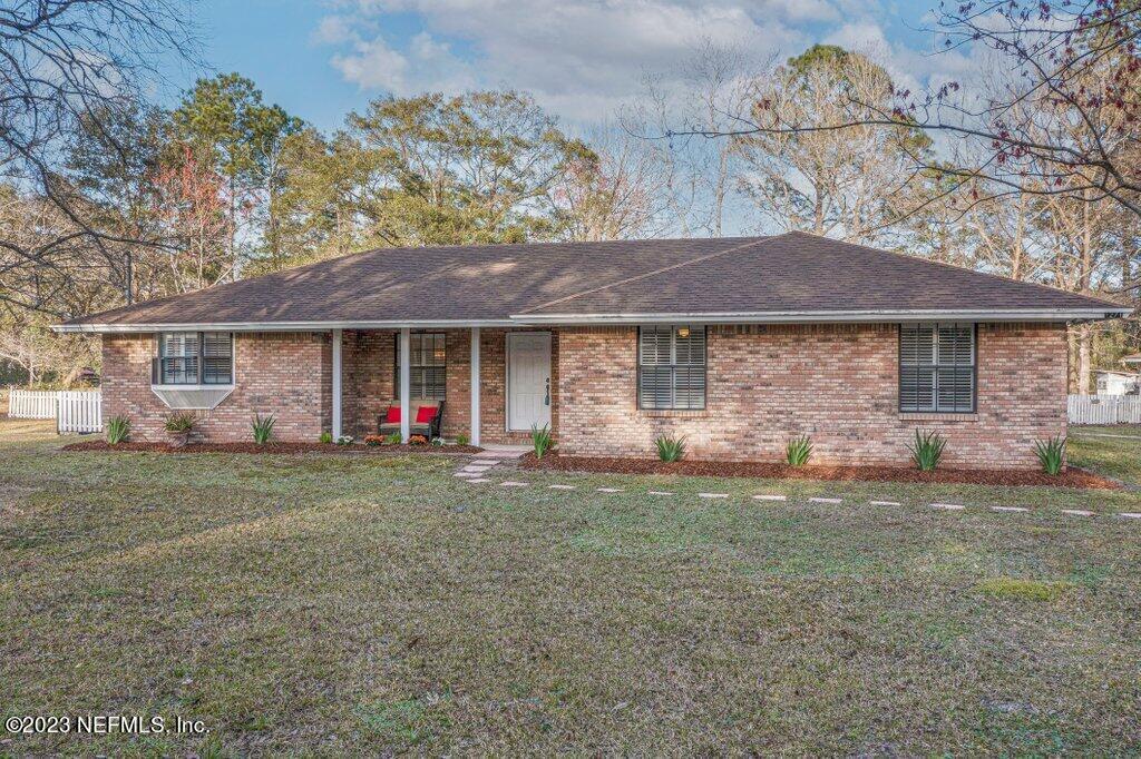 1271 Sheffield Road Jacksonville, FL 32259 - Photo 1 of 19 a front view of a house with a garden and trees