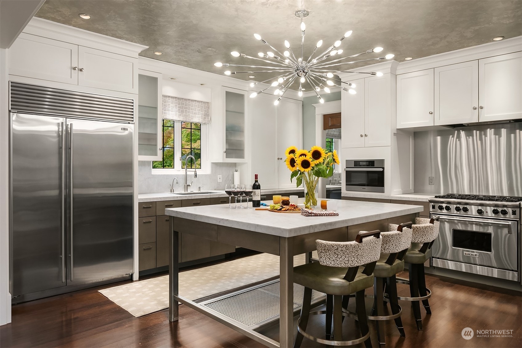 1121 22nd Avenue East Seattle, WA 98112 - Photo 7 of 40 a kitchen with stainless steel appliances a dining table chairs refrigerator and stove