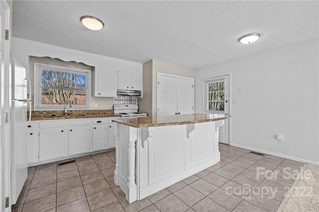 2328 Weddington Road Charlotte, NC 28270 - Photo 12 of 24 a kitchen with cabinets and wooden floor